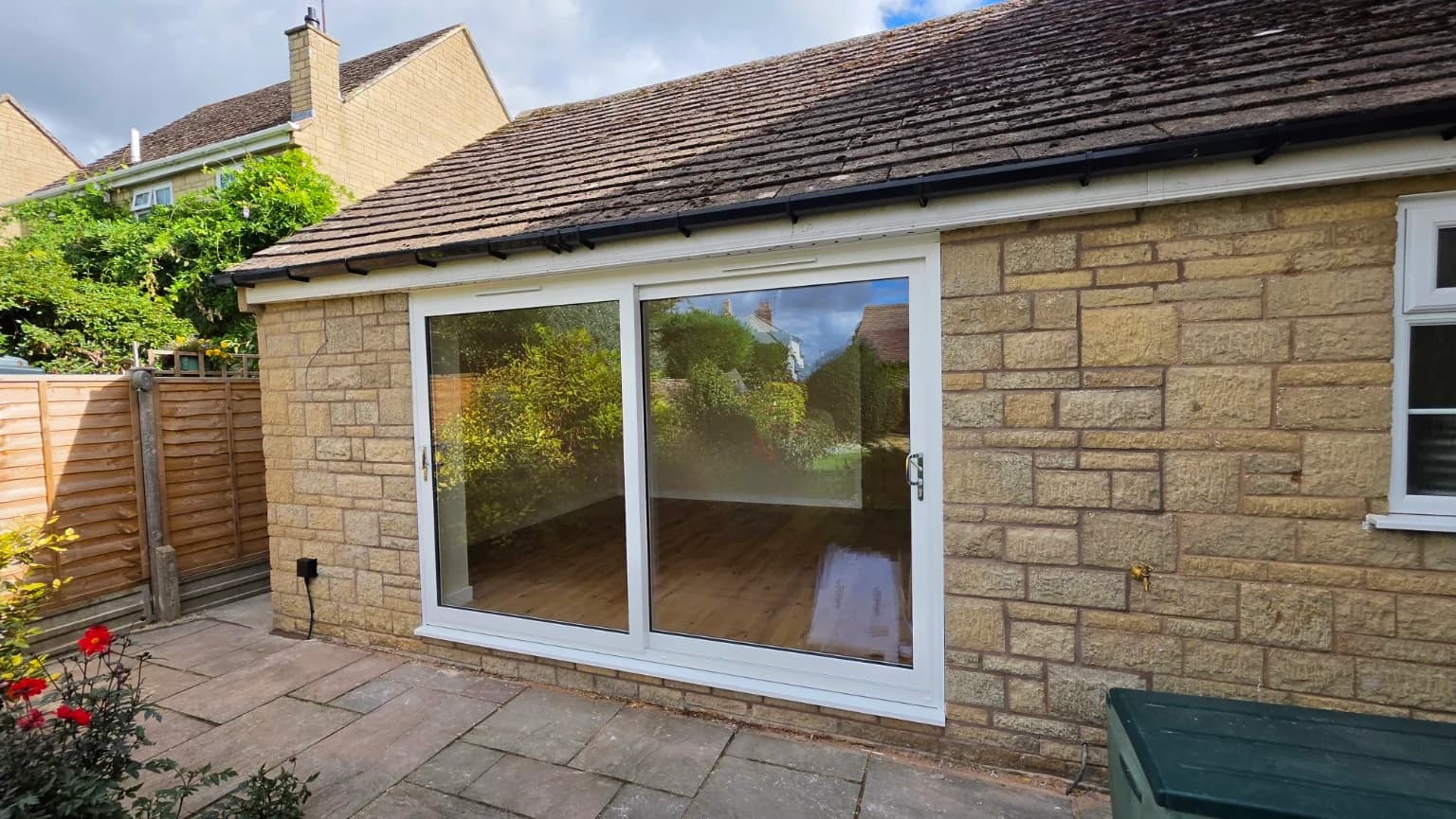 Completed Mickleton garage conversion exterior with wide white-framed sliding glass doors