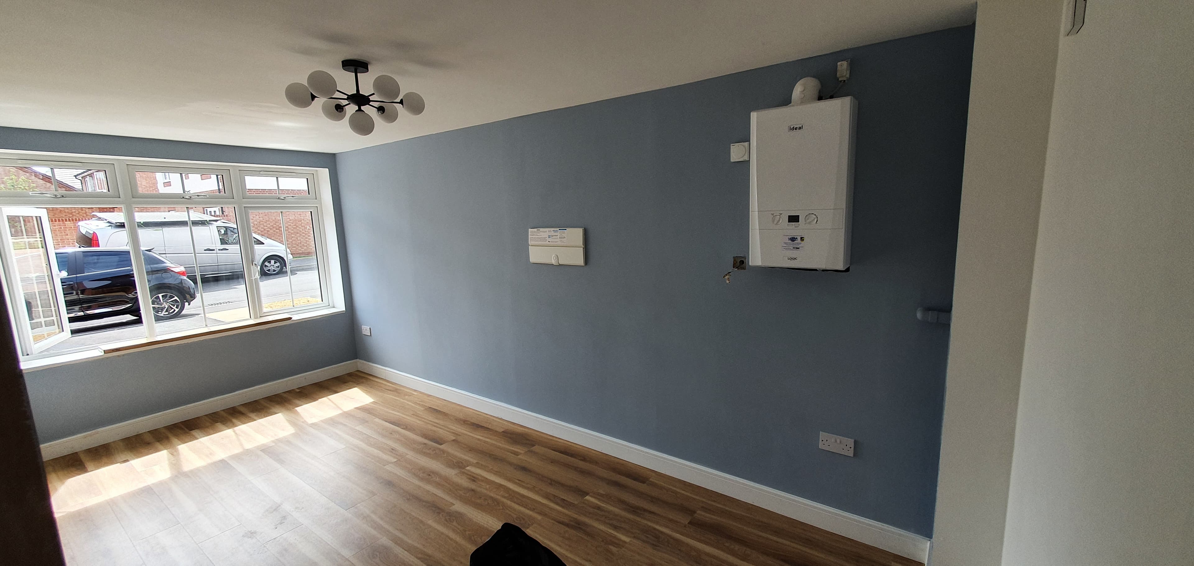Finished garage conversion room in Southam with blue walls and a wide window
