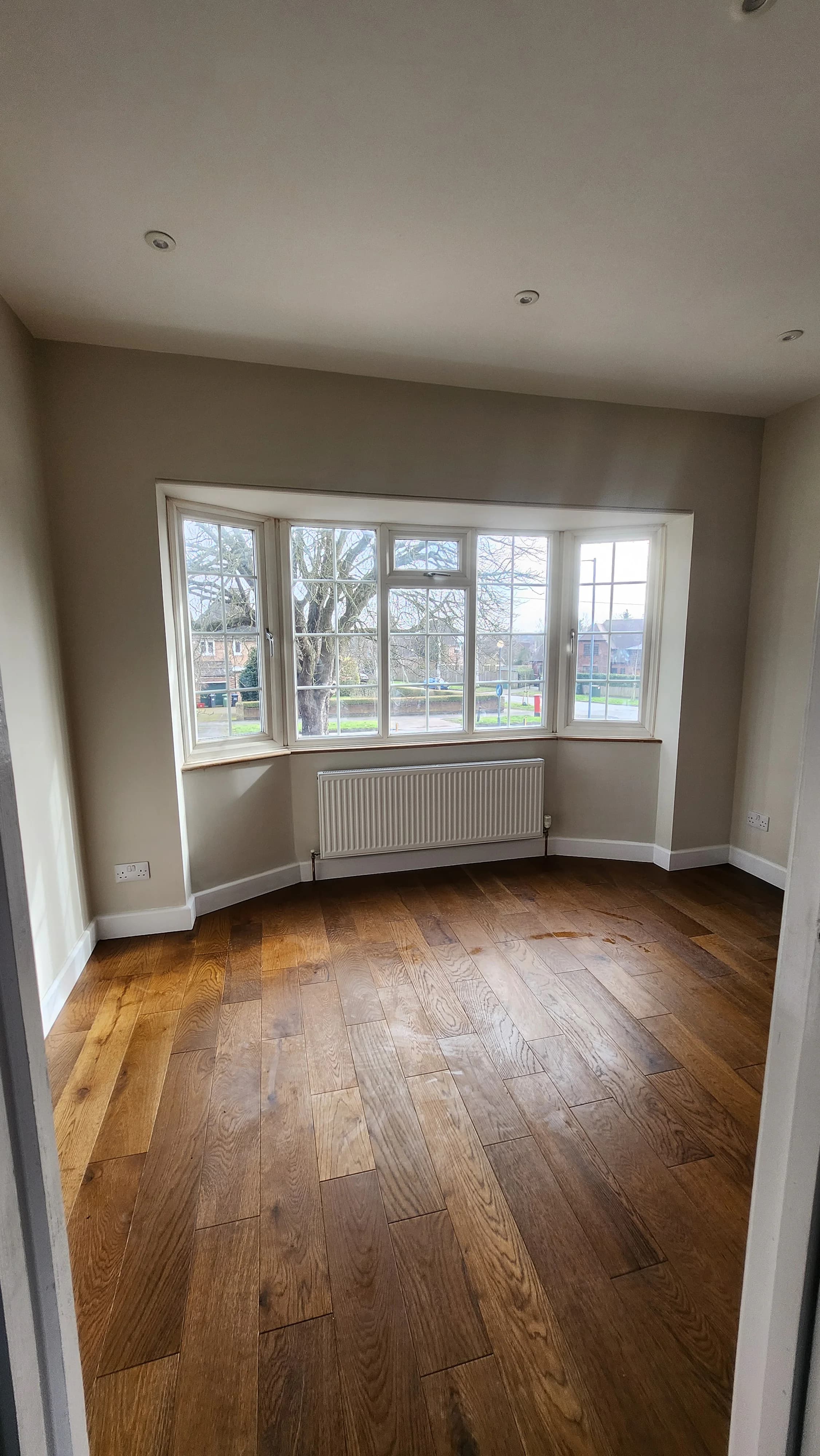 Finished Northumberland Road bedroom with a bay window, wooden floor and radiator