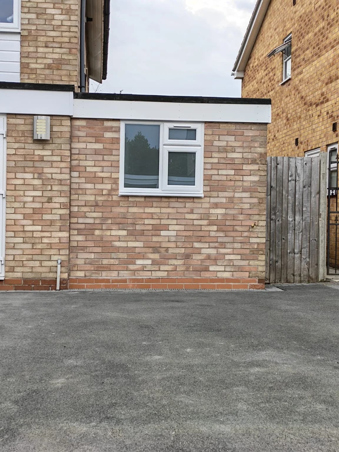 Finished brick frontage and white-framed window replacing the Wellesbourne garage door