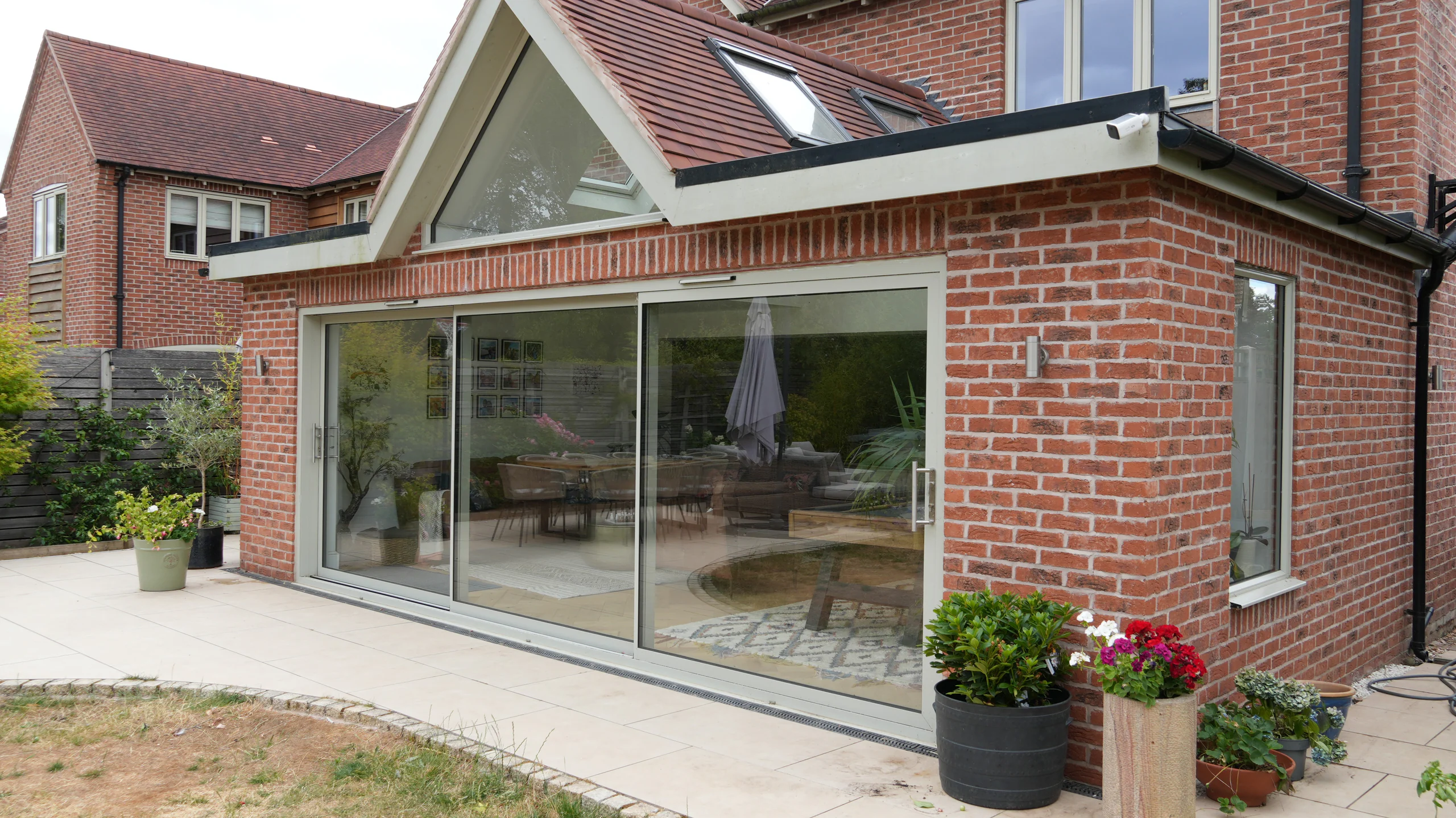 Completed red-brick rear extension with a glazed gable and wide sliding doors